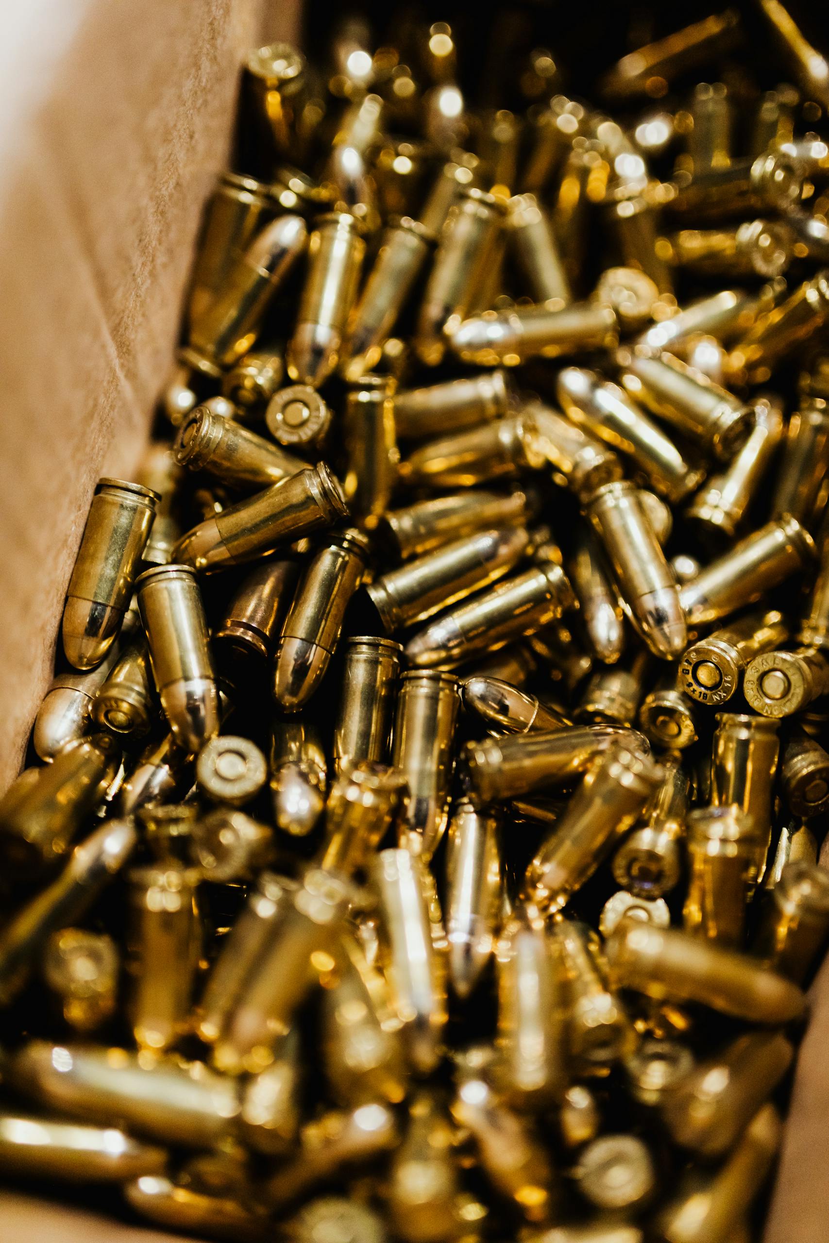 Detailed close-up of brass bullets in a box, showcasing ammunition storage.
